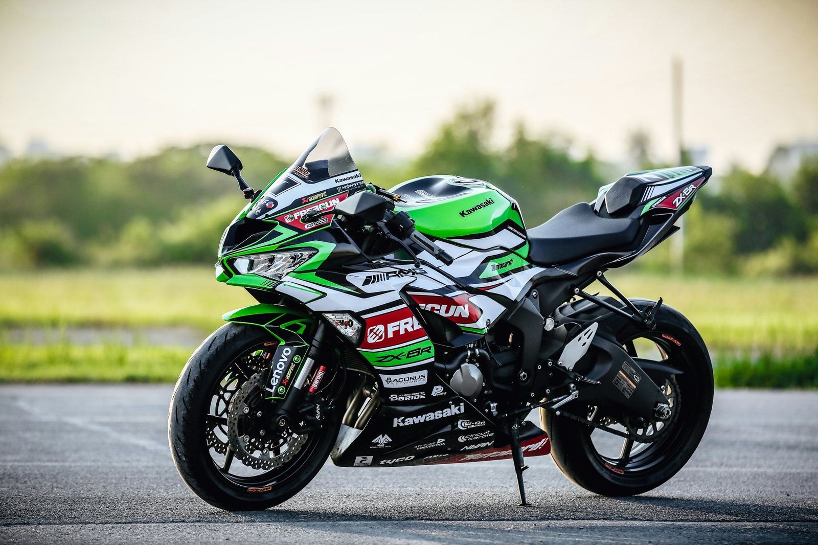 A green Kawasaki Ninja ZX-6R sport bike in a race-style livery, seen from the left side