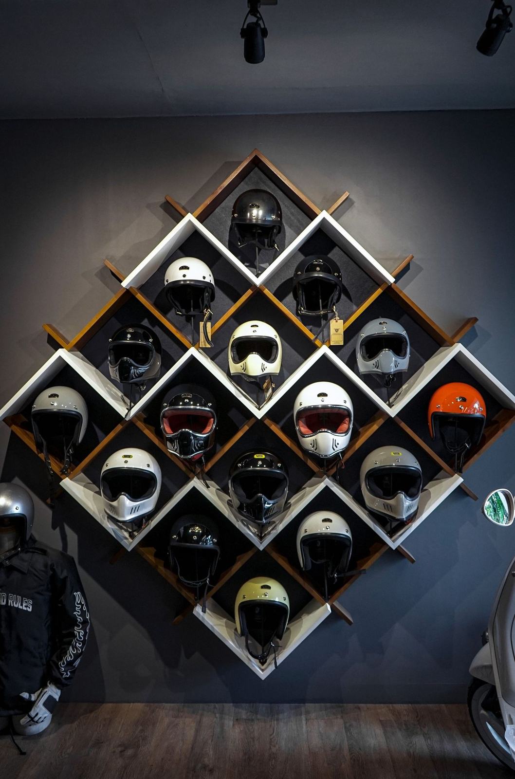 Helmets in many colours on diamond-shaped wall shelves