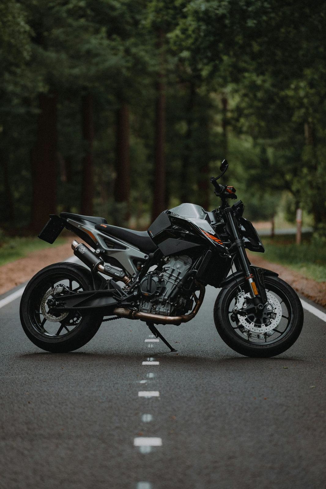 A black KTM 790 Duke parked on a forest road, seen from the right side